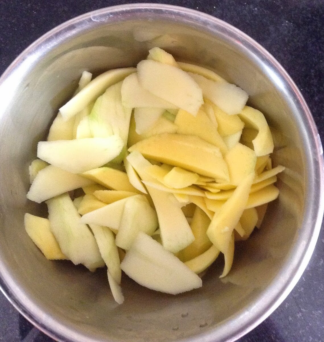 Peeling and chopping the raw mangoes or ambi.