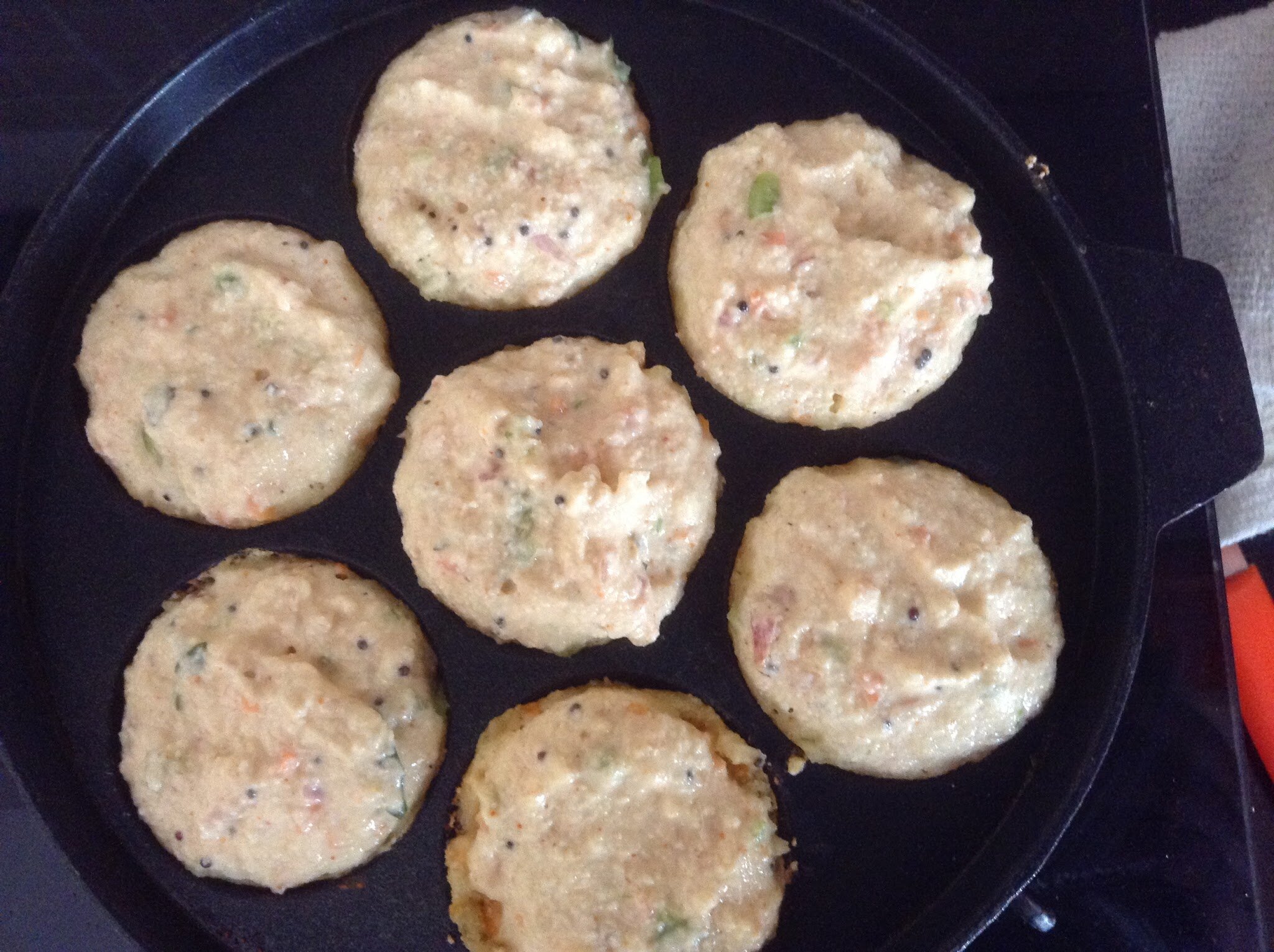 Cooking rava batter in appe stand.