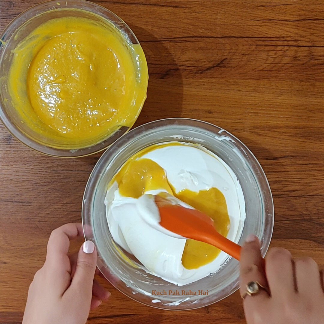 Folding mango pulp in whipped cream.