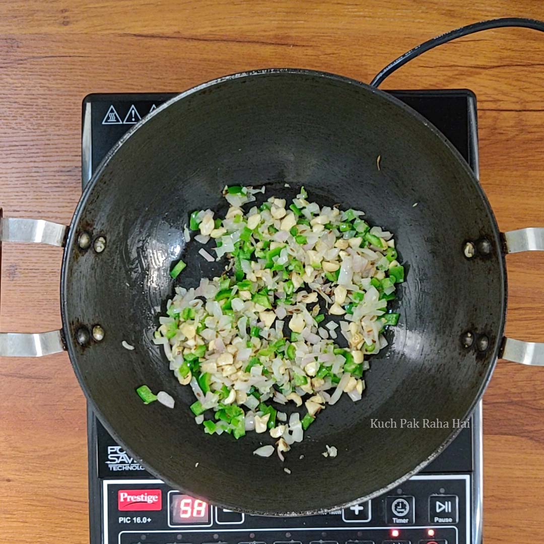 Sautéing cashews and capsicum with onions.