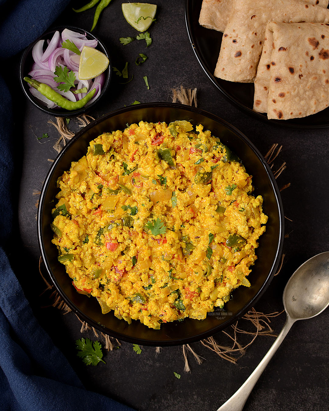 Indian spices scrambled cottage cheese served in a black bowl.