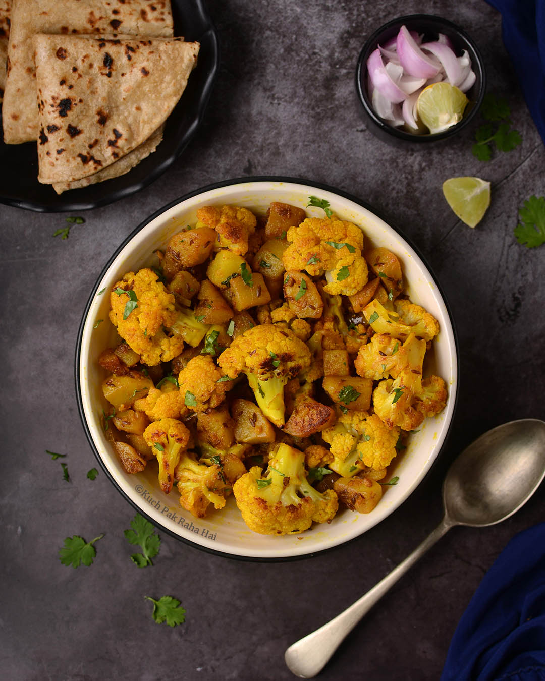 Aloo Gobhi served in white bowl with roti.