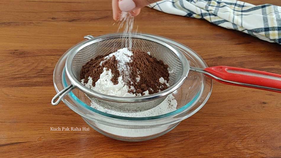 Sieving dry ingredients in a bowl.