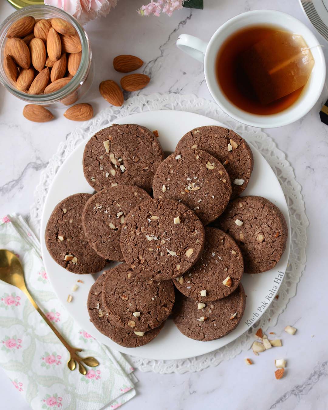 Almond chocolate cookies served on a plate with tea.