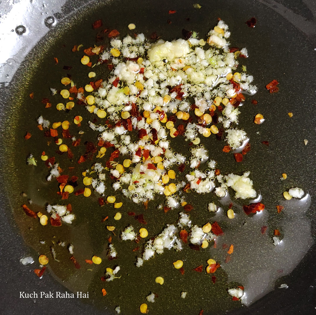 Sautéing garlic & chilli flakes in olive oil.