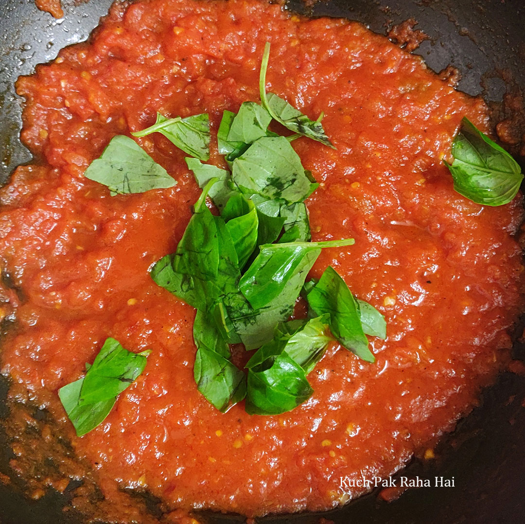 Adding fresh basil to arrabiata sauce.