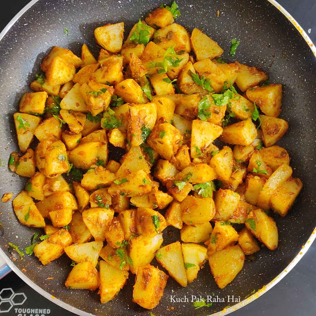 Garnishing potatoes with fresh herbs.