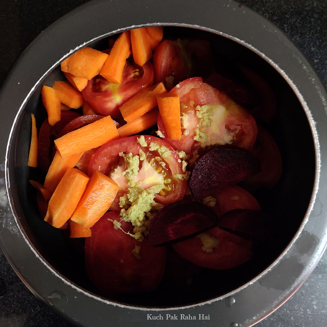 Adding tomatoes carrots beetroot in a pressure cooker.