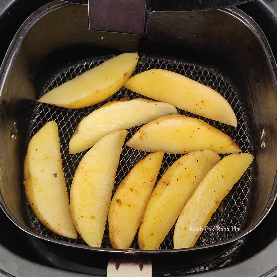 Arranging wedges in preheated air fryer basket.