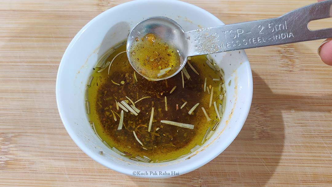 Mixing olive oil & seasoning in a bowl.