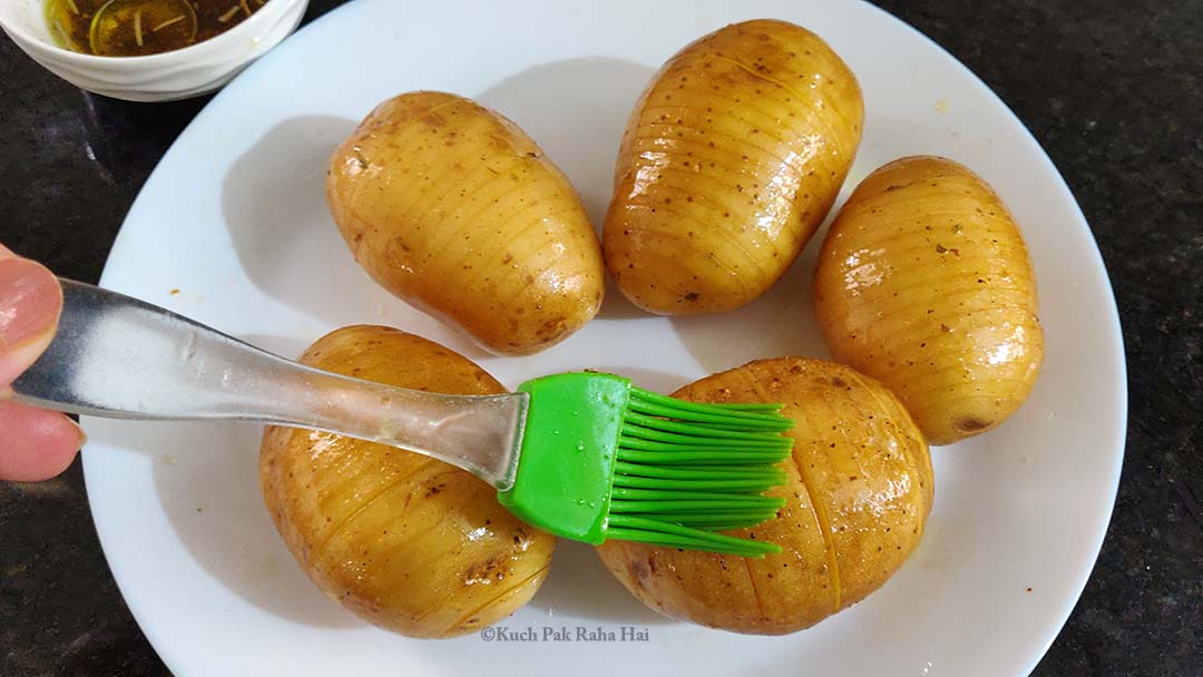 Brushing potatoes with oil & seasoning.