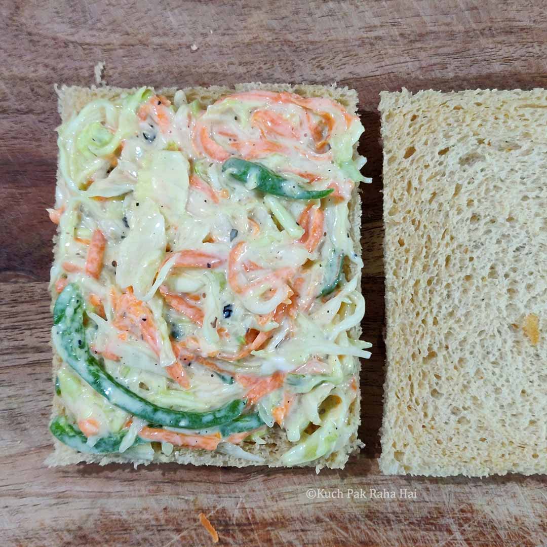 Preparing coleslaw sandwich.