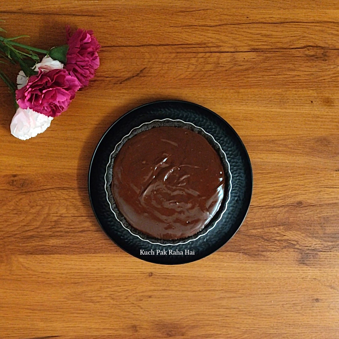 Filling ganache in chocolate tart.