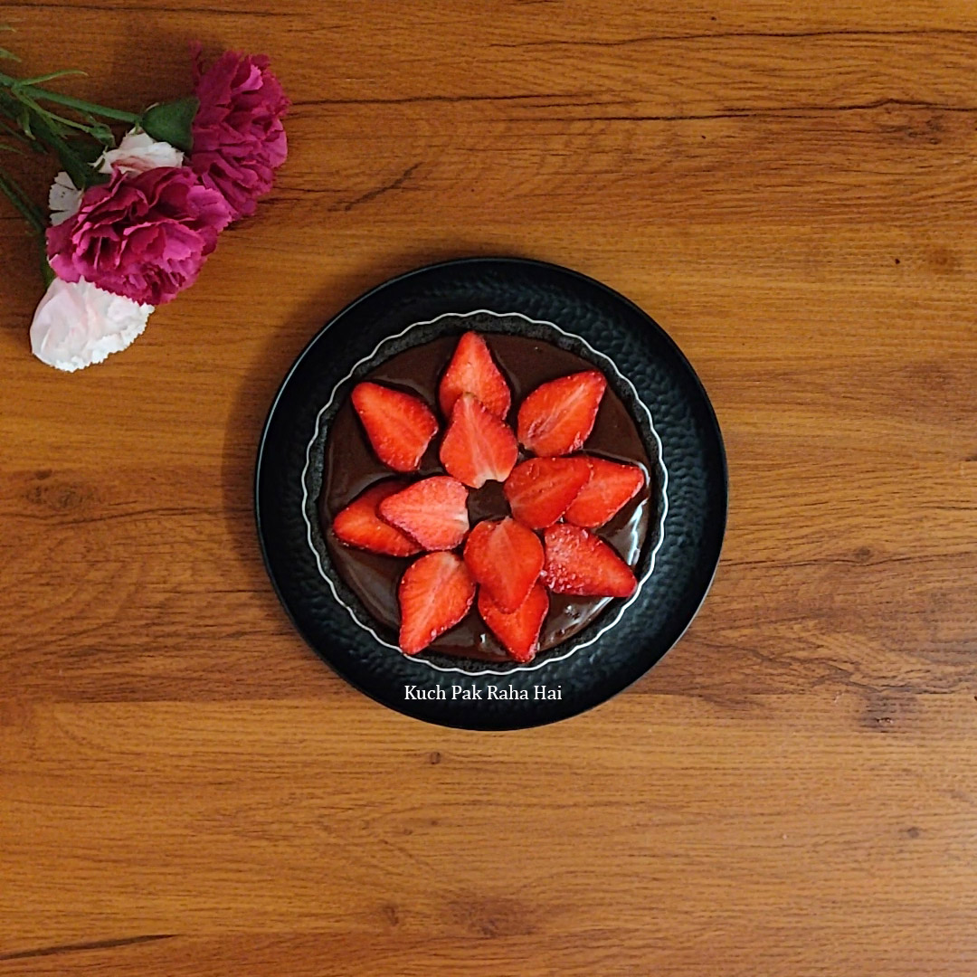 Decorating chocolate tart with strawberries.