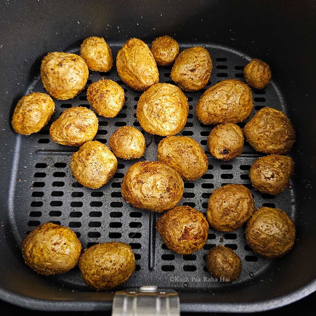 Adding spices to baby potatoes.
