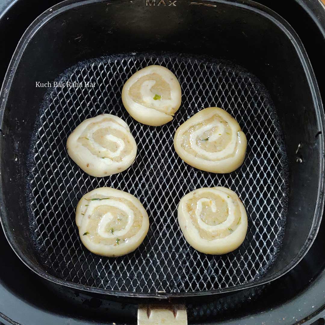 Uncooked samosa pinwheel in air fryer basket.