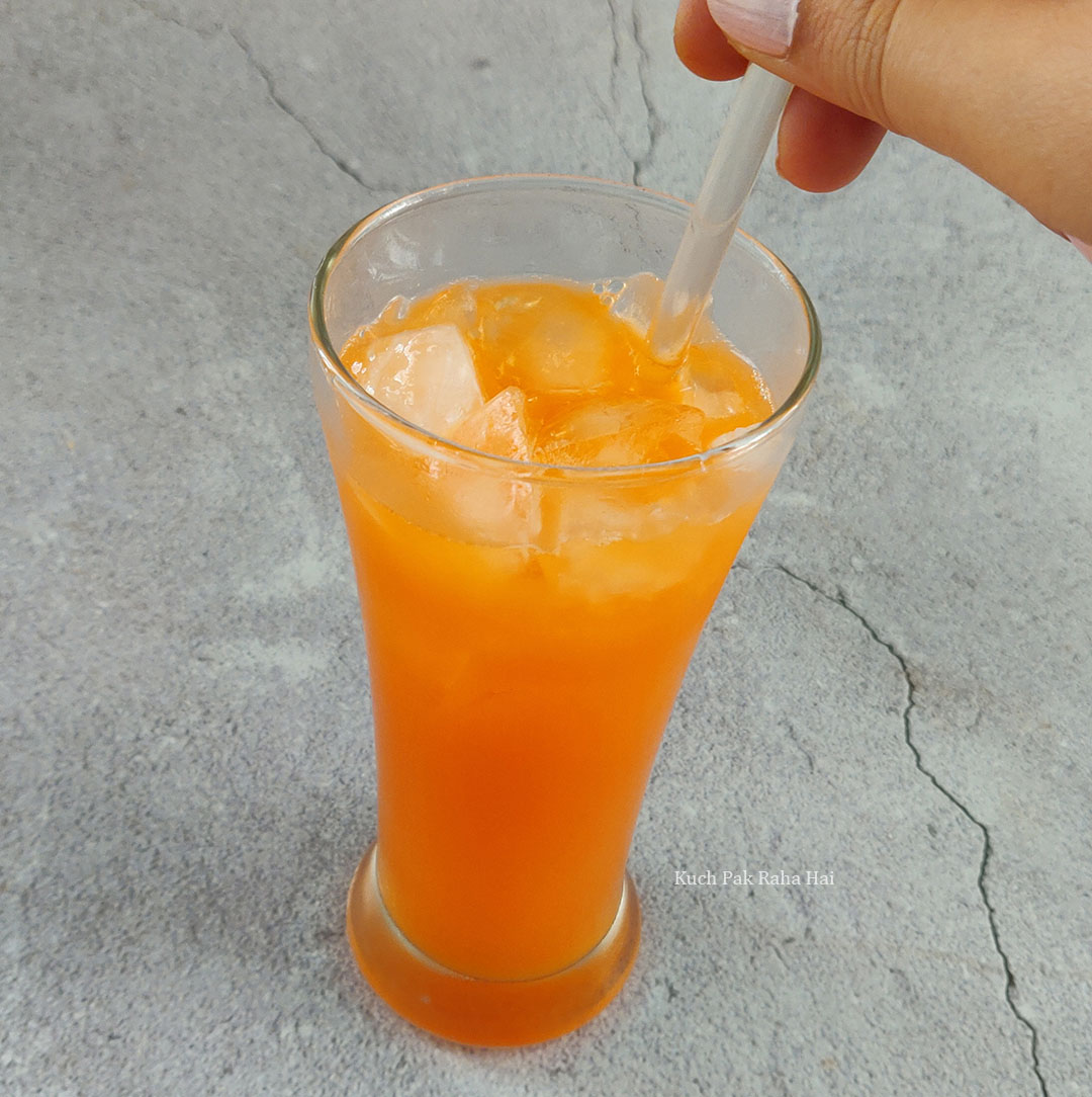 Pouring orange juice in tall glass.