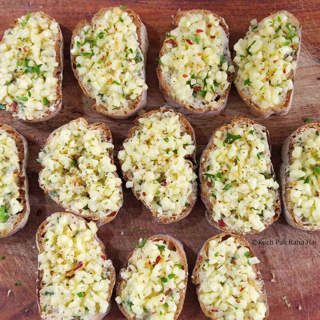 Adding shredded cheese on slices.