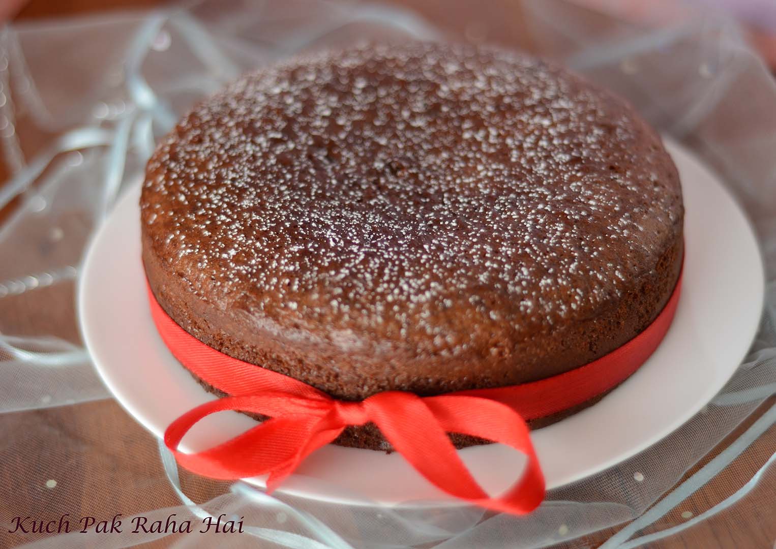 Eggless Chocolate Cake dusted with powdered sugar.