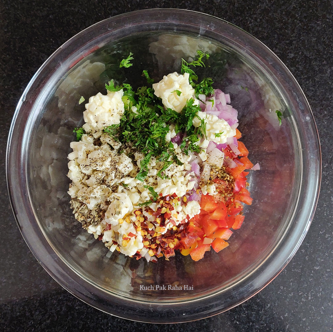 Mixing vegetables, cheese & seasoning in a bowl.