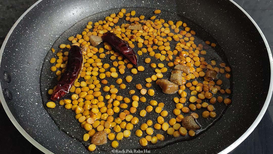 Adding water to roasted chana.