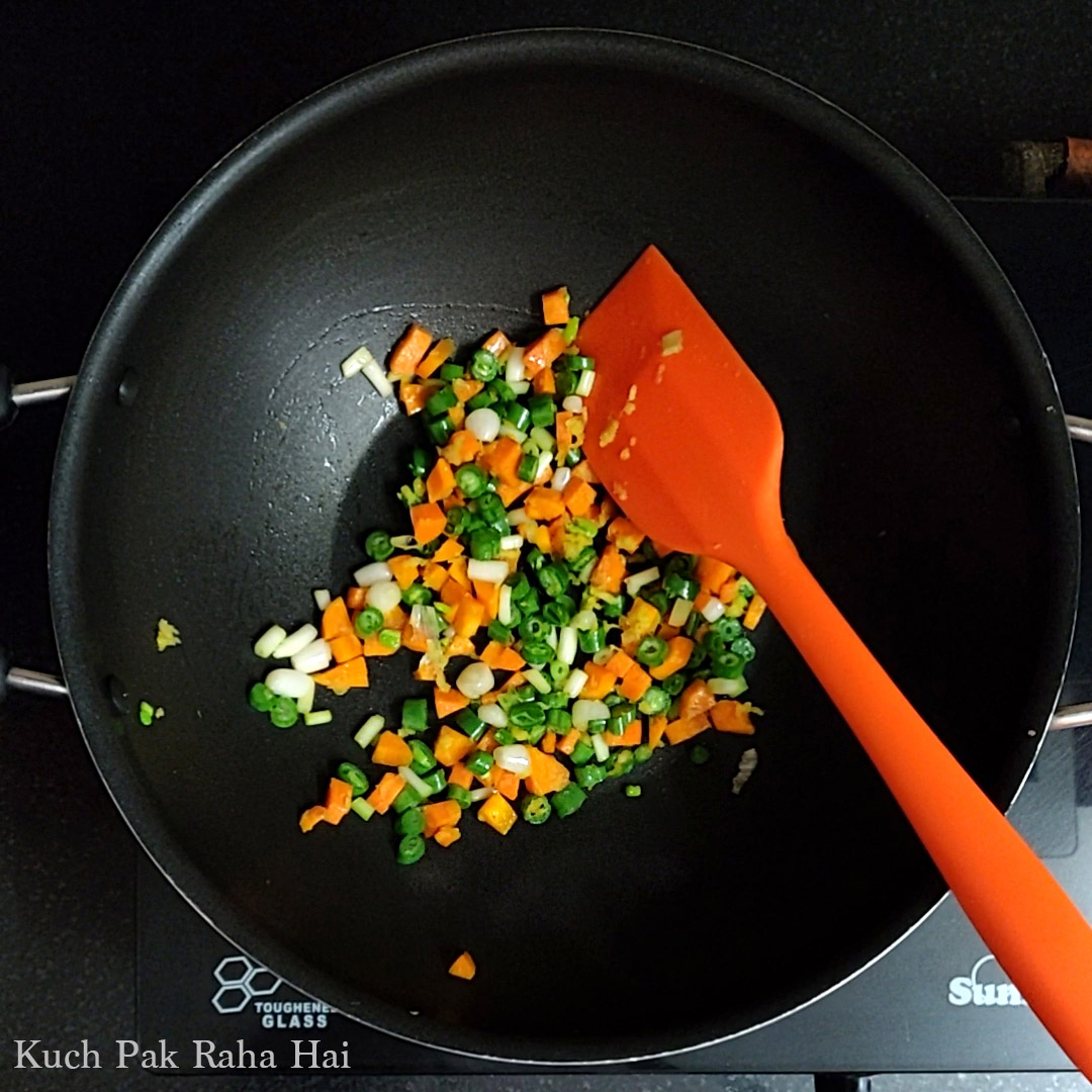 Sautéing vegetables in a pan.