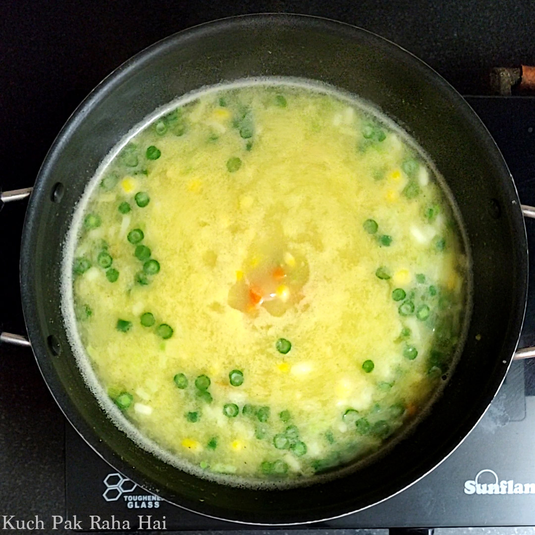 Adding sweet corn and water to the pan.