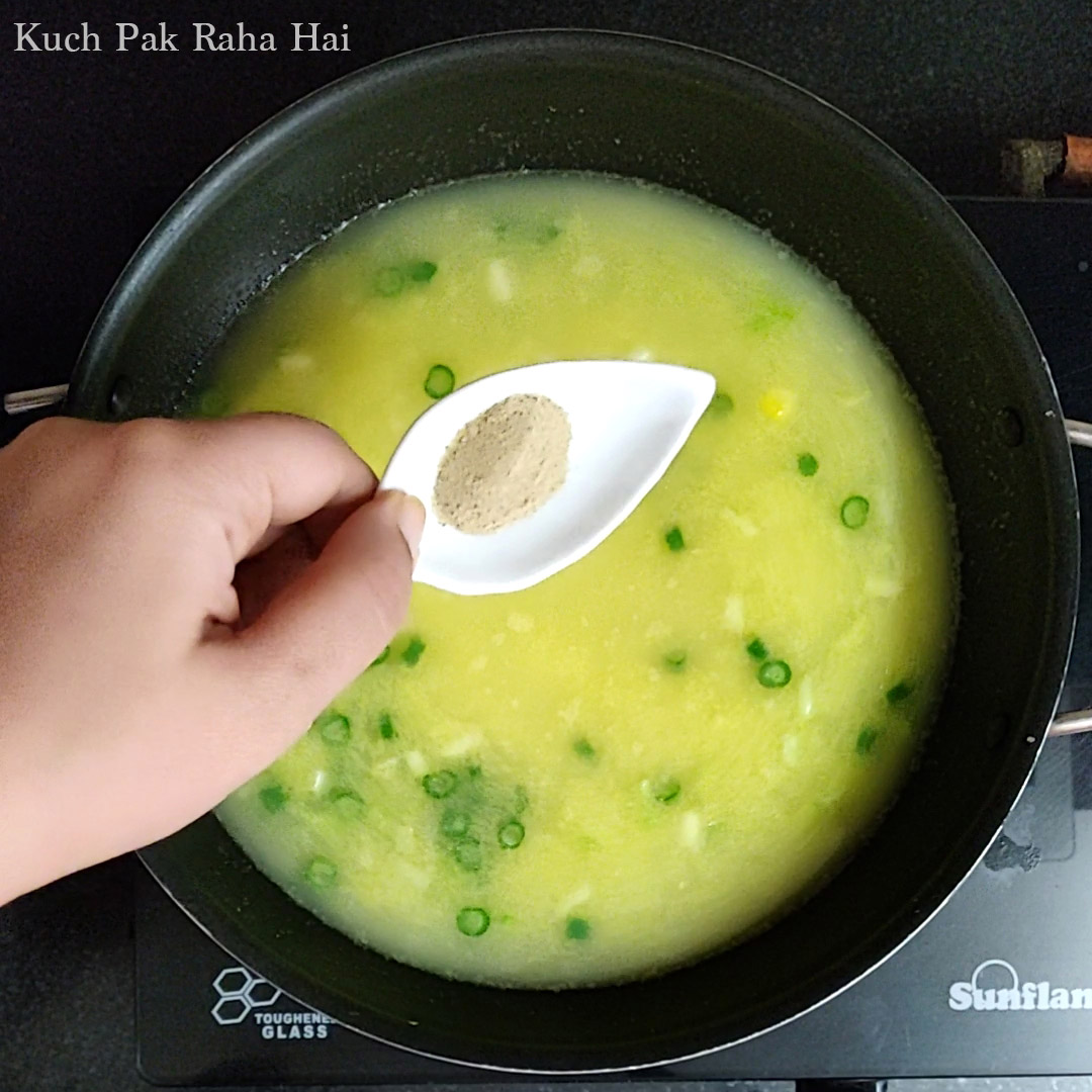 Adding seasoning to corn soup.