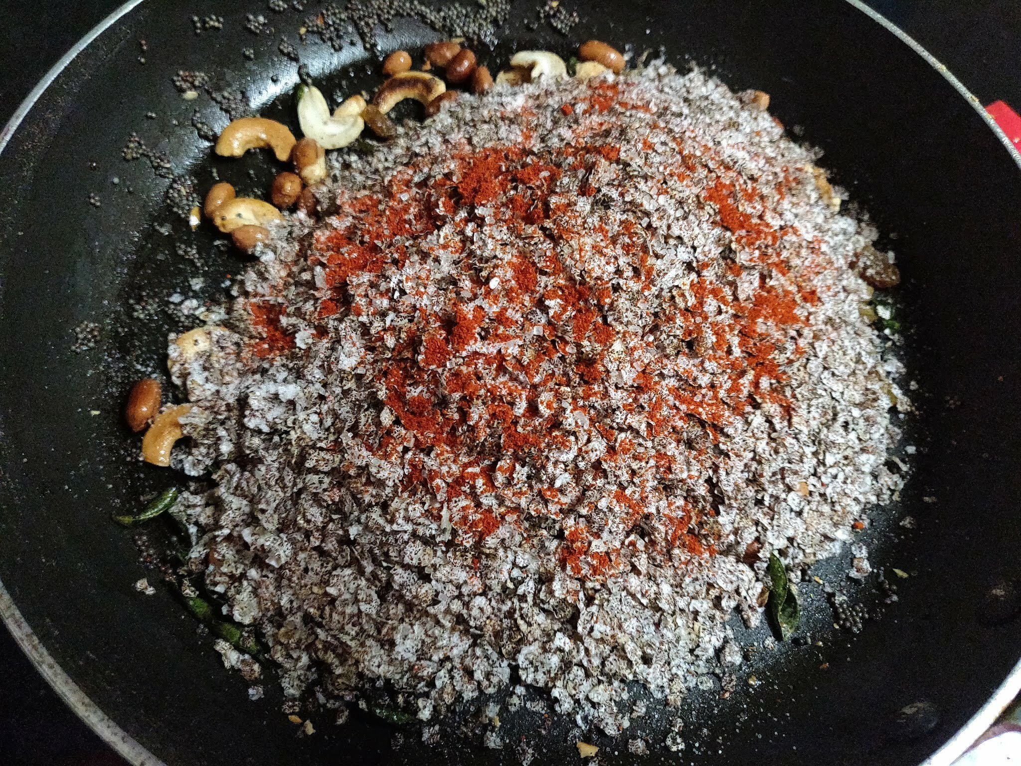 Adding spices to chivda.