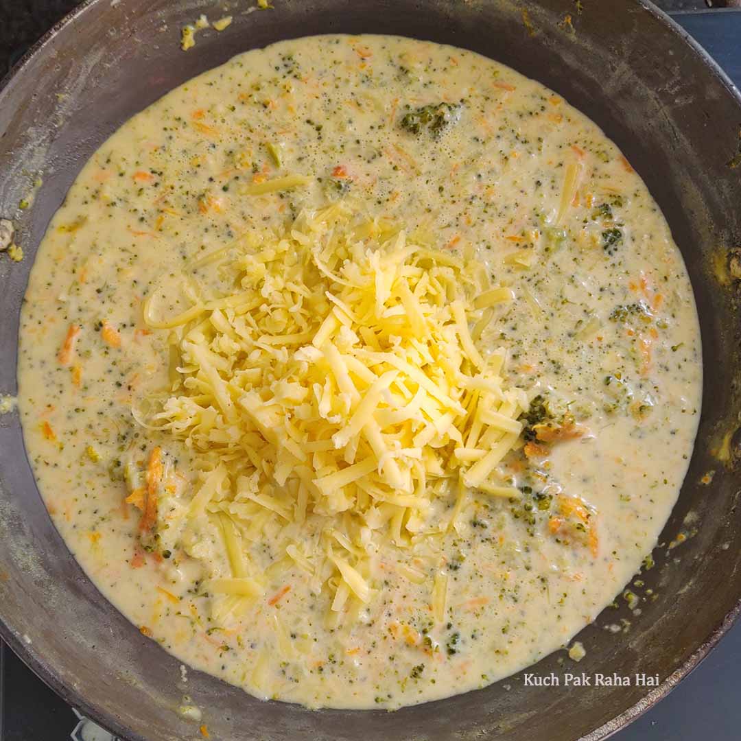 Adding cheese to broccoli soup.