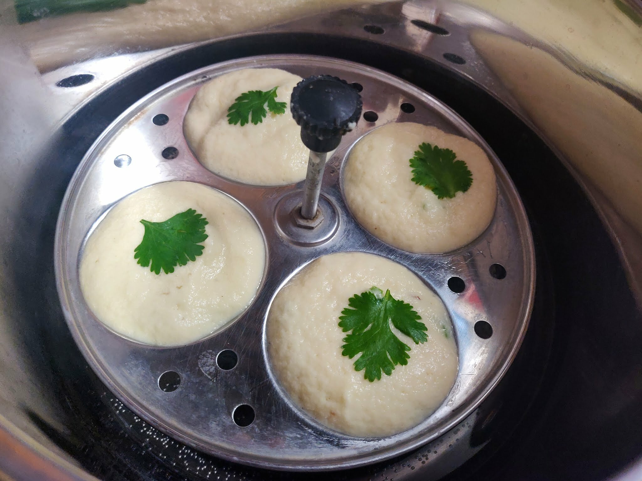 Placing idli stand inside the steamer.