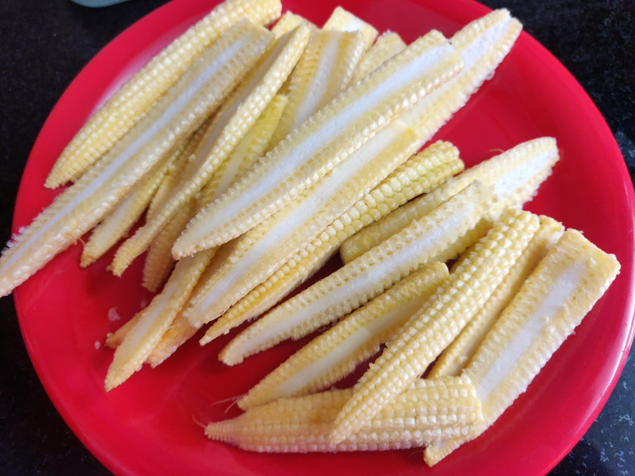 Cleaning and slicing the baby corns.
