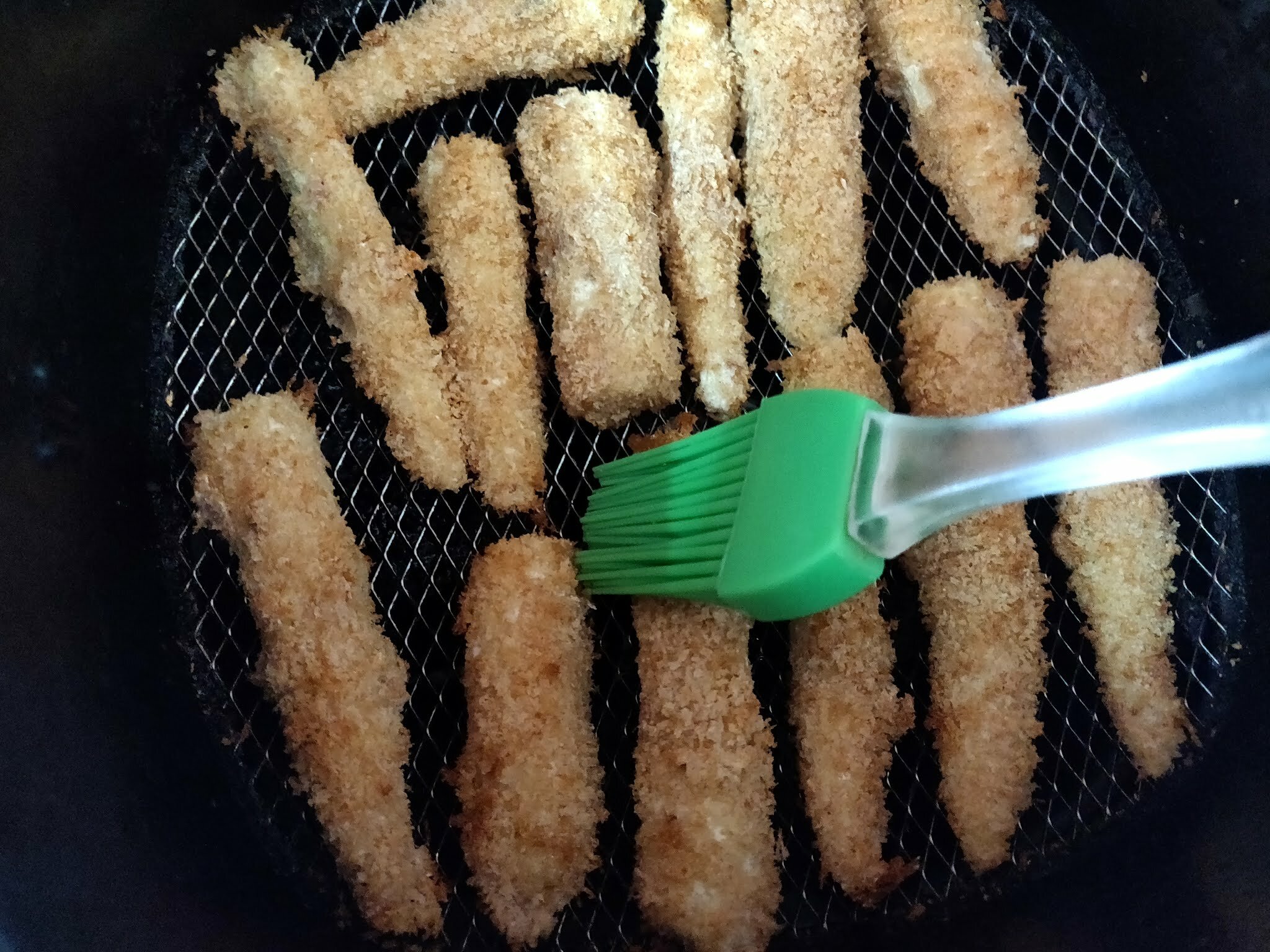 Brushing oil on air fried baby corns.
