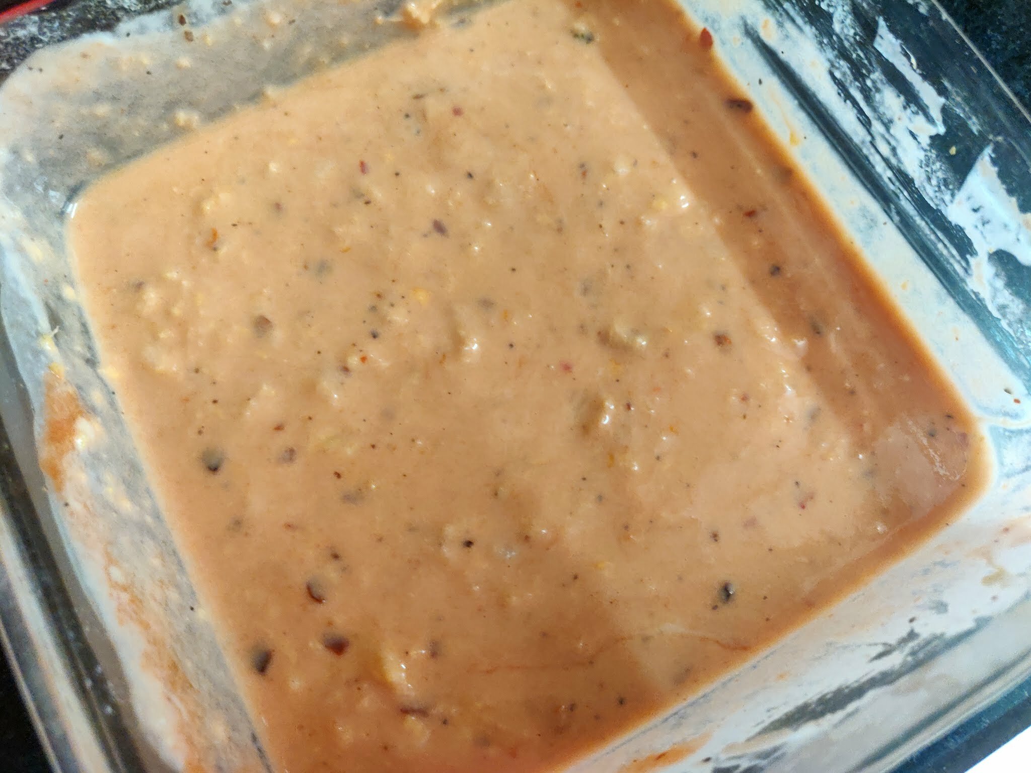 Mixing flour with sauces and spices to make batter.