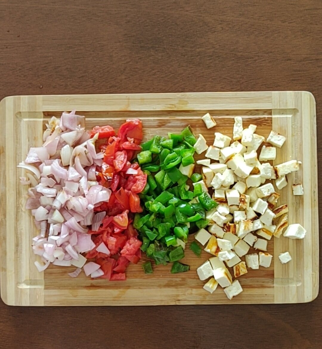 Chopping grilled vegetables and paneer.