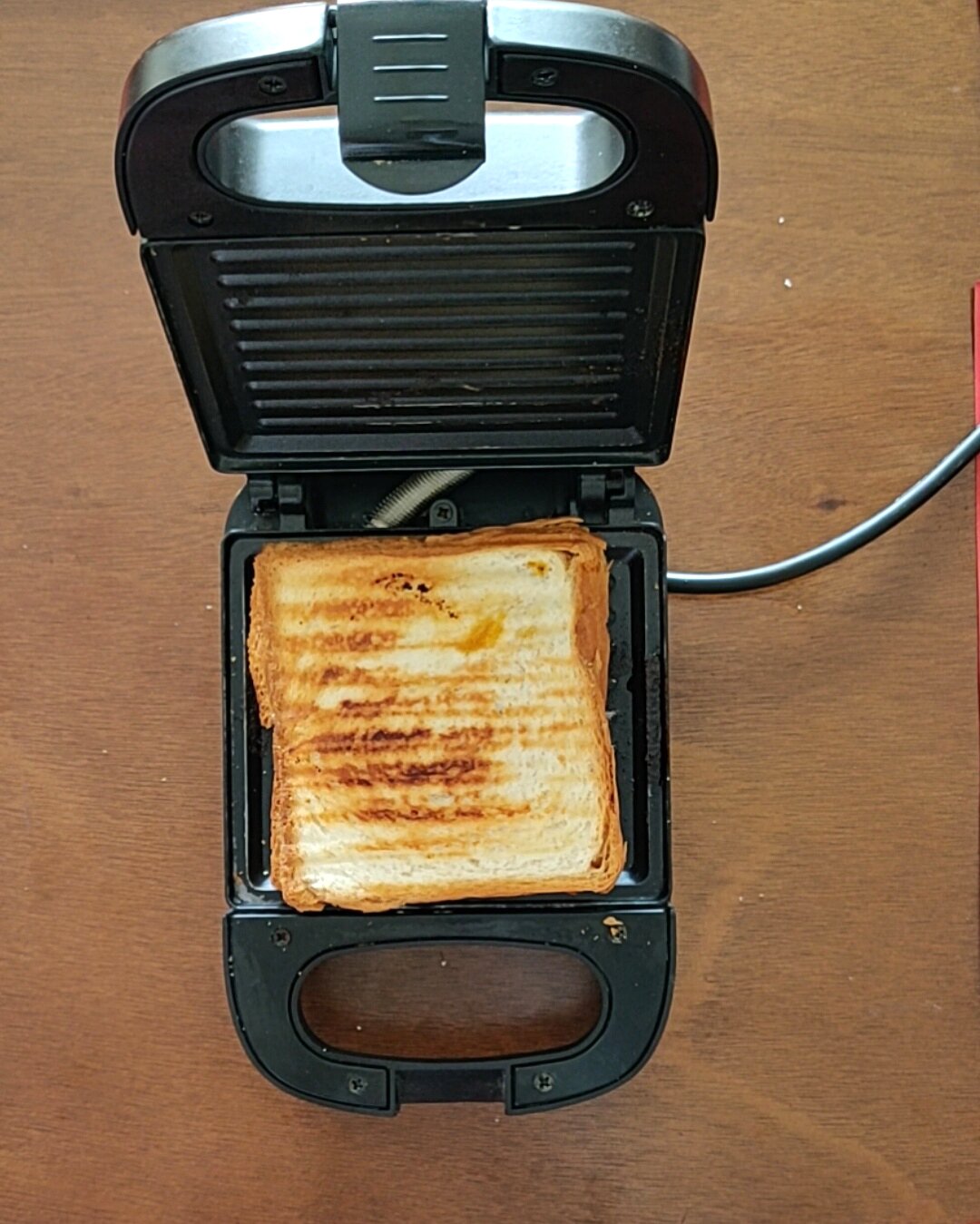 Grilling paneer tikka sandwich in sandwich maker.