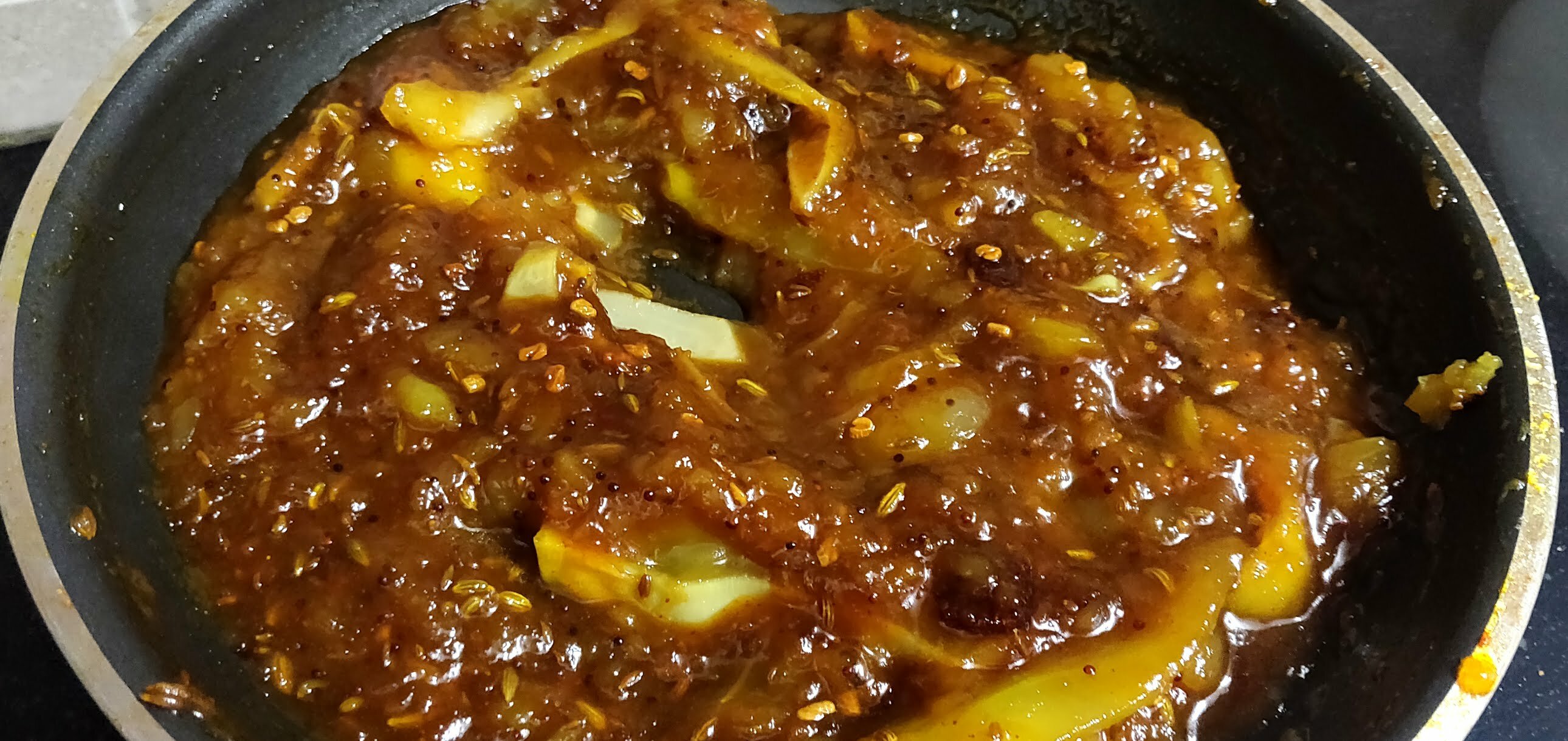 Aam ki launji cooking in a pan.