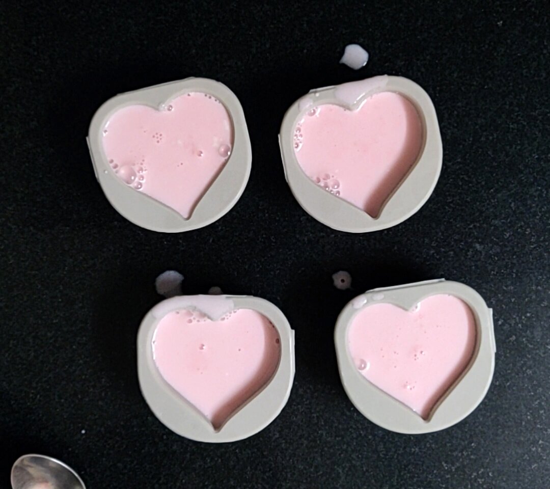 Transferring rose pannacotta mixture in silicon moulds.