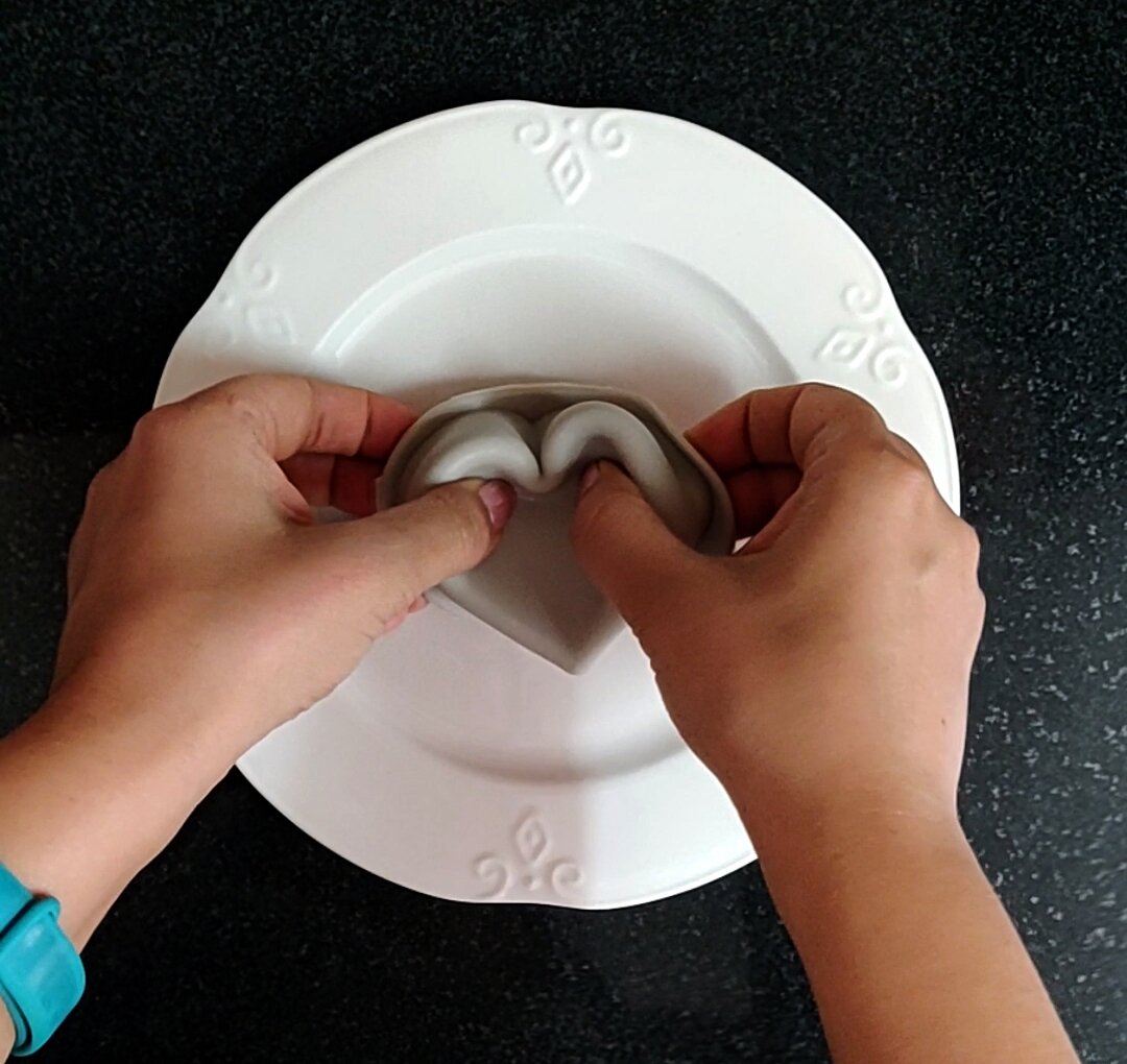 De-moulding panna cotta on a plate.