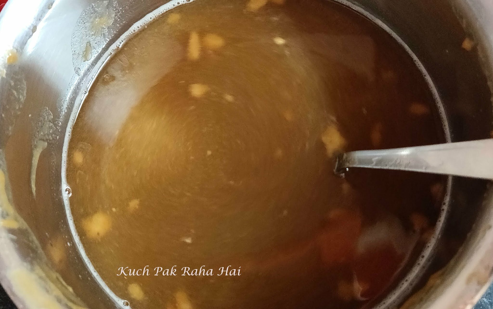 Adding jaggery & water to tamarind pulp.