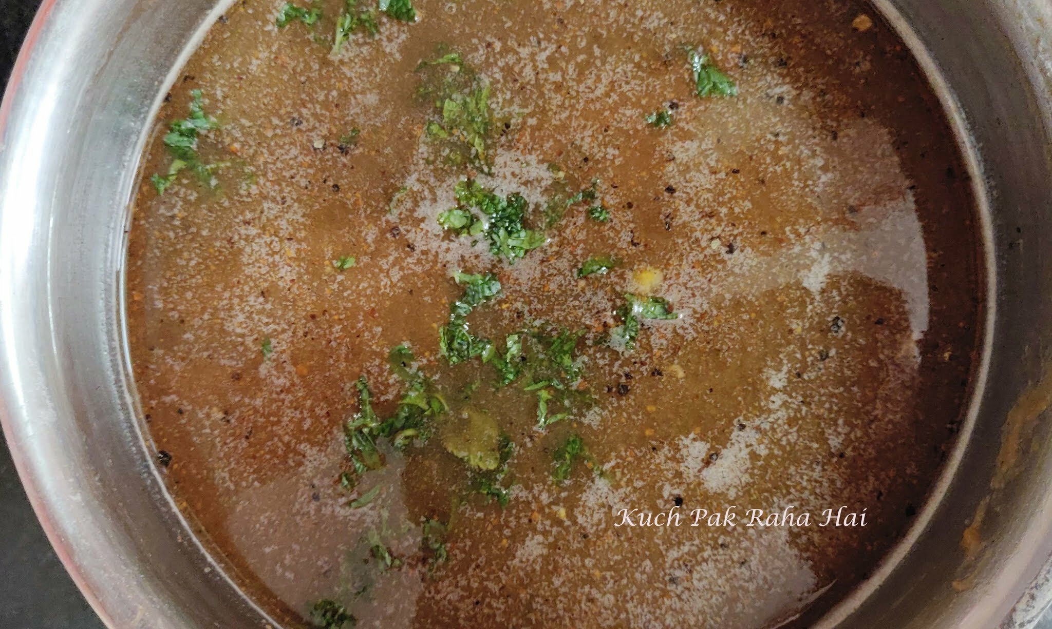 Adding fresh mint leaves to imli panna.