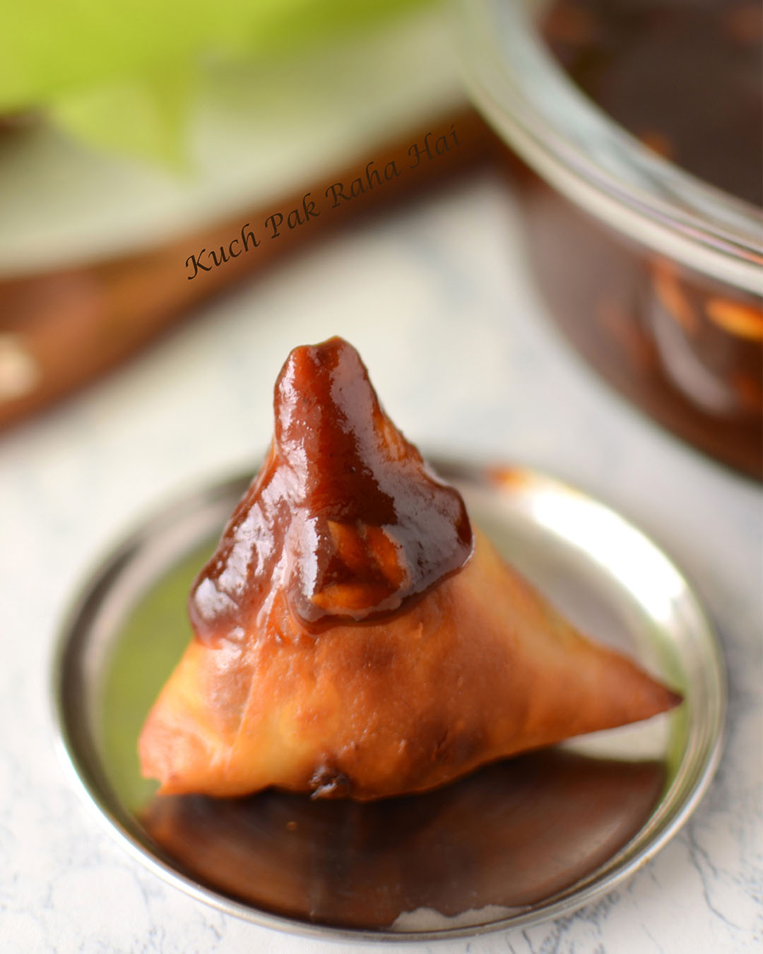 Indian sweet cour tamarind chutney served with samosa