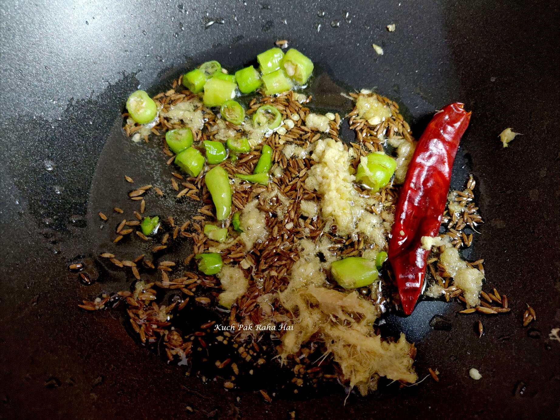 Sautéing spices in ghee or oil.