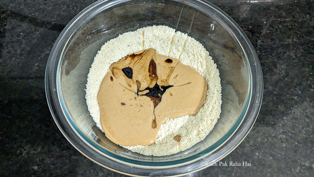 Adding peanut butter, vanilla extract to almond flour.