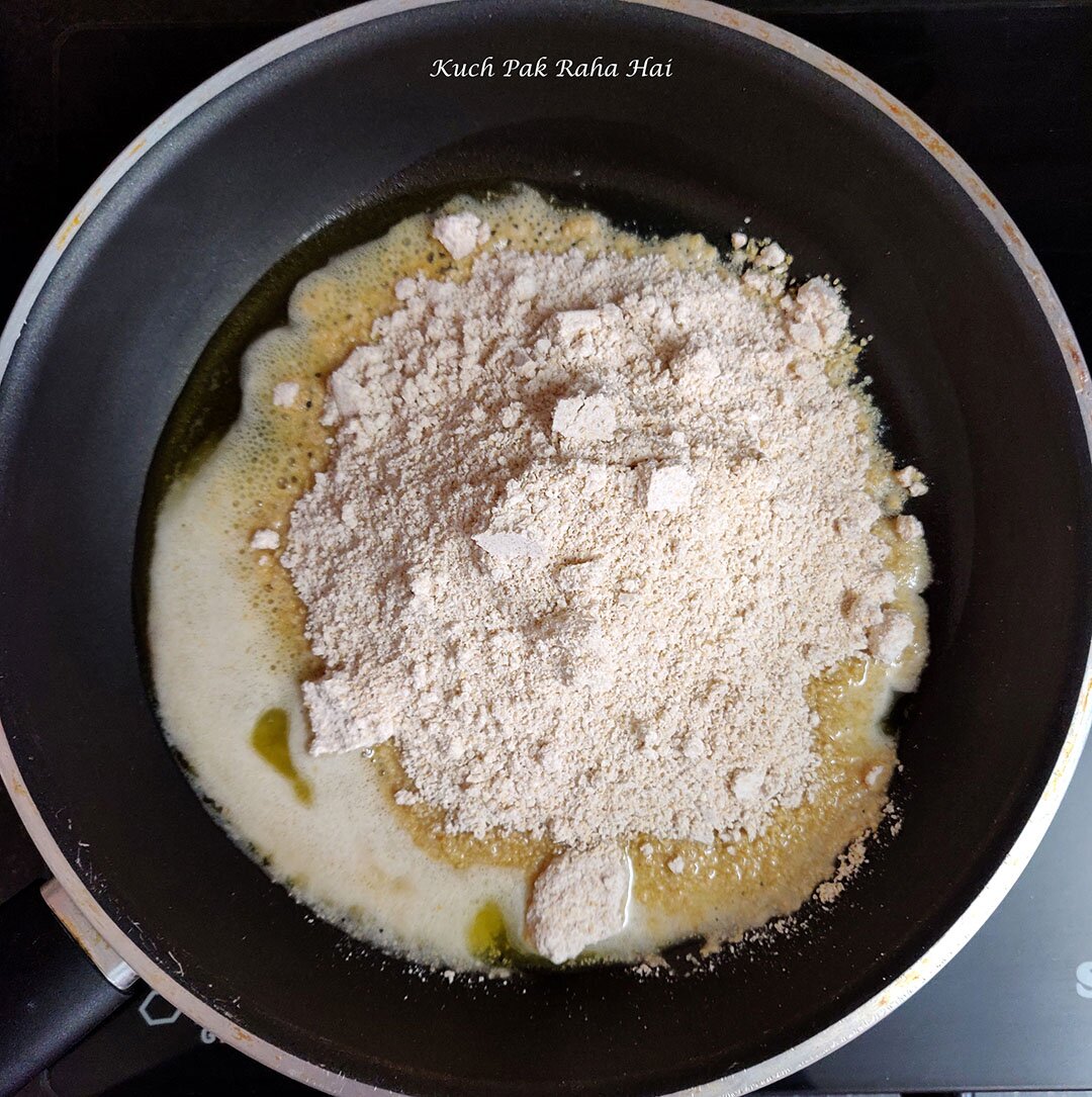 Roasting powdered oats in ghee.