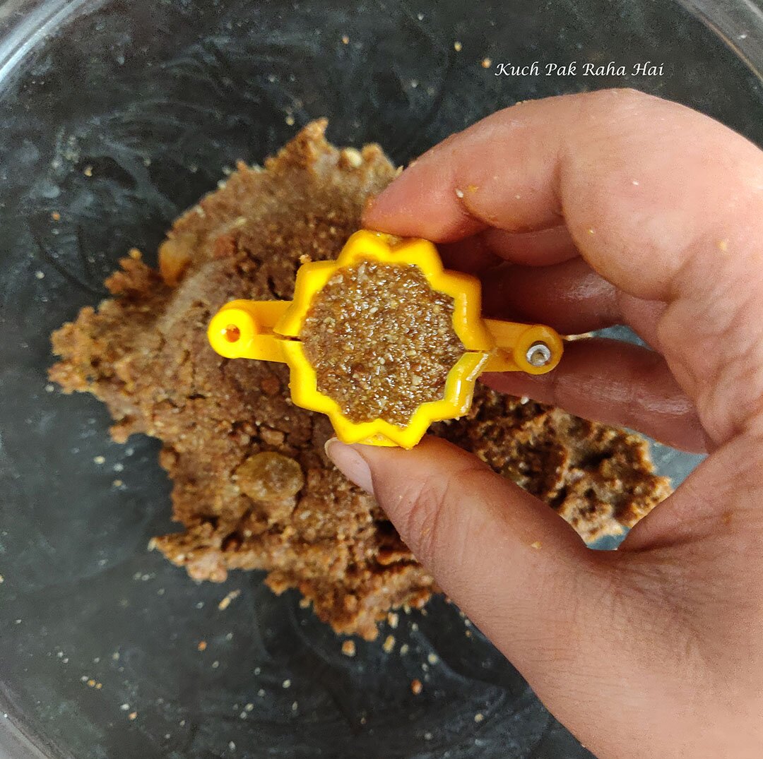 Shaping modak by stuffing the mixture in moulds.