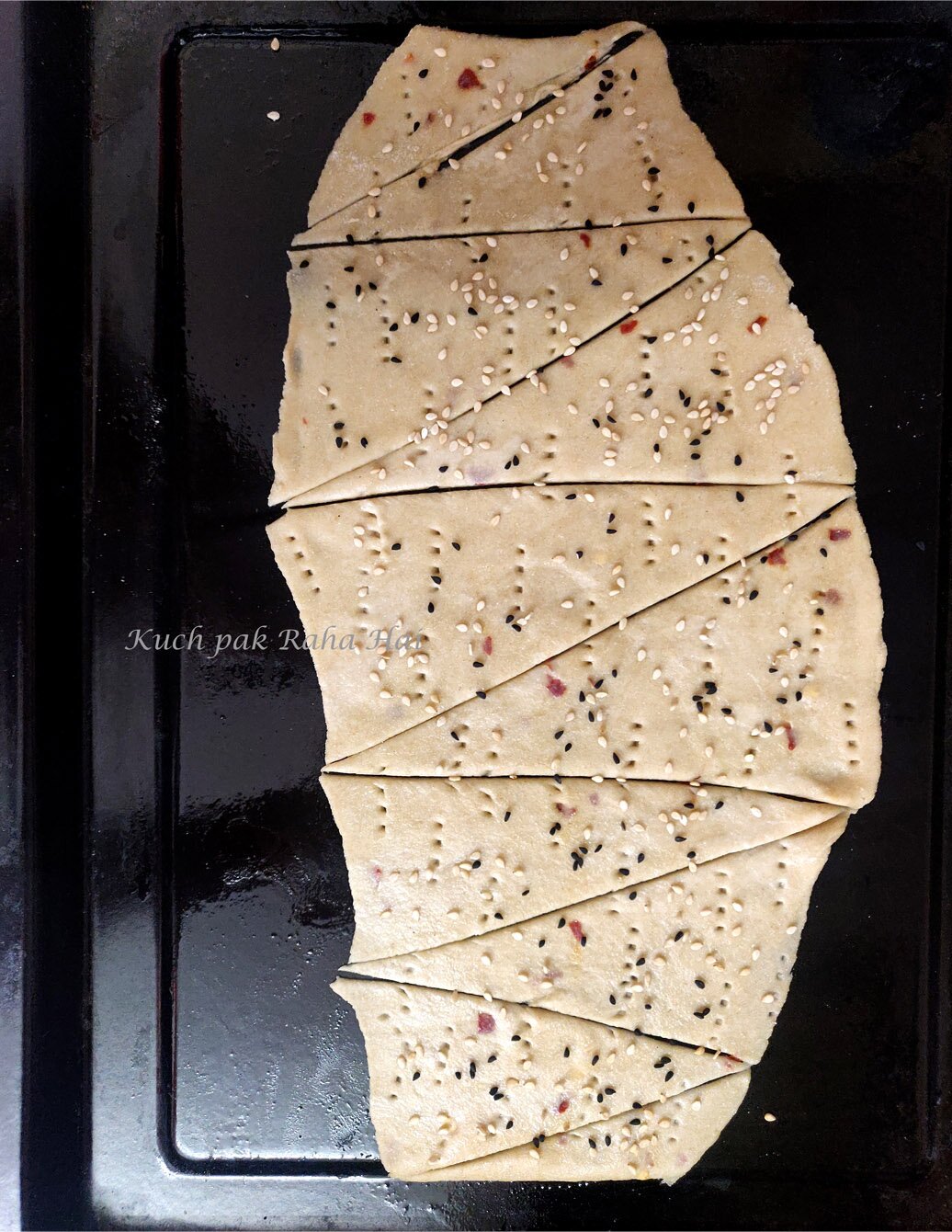 Sprinkling sesame seeds over lavash crackers.