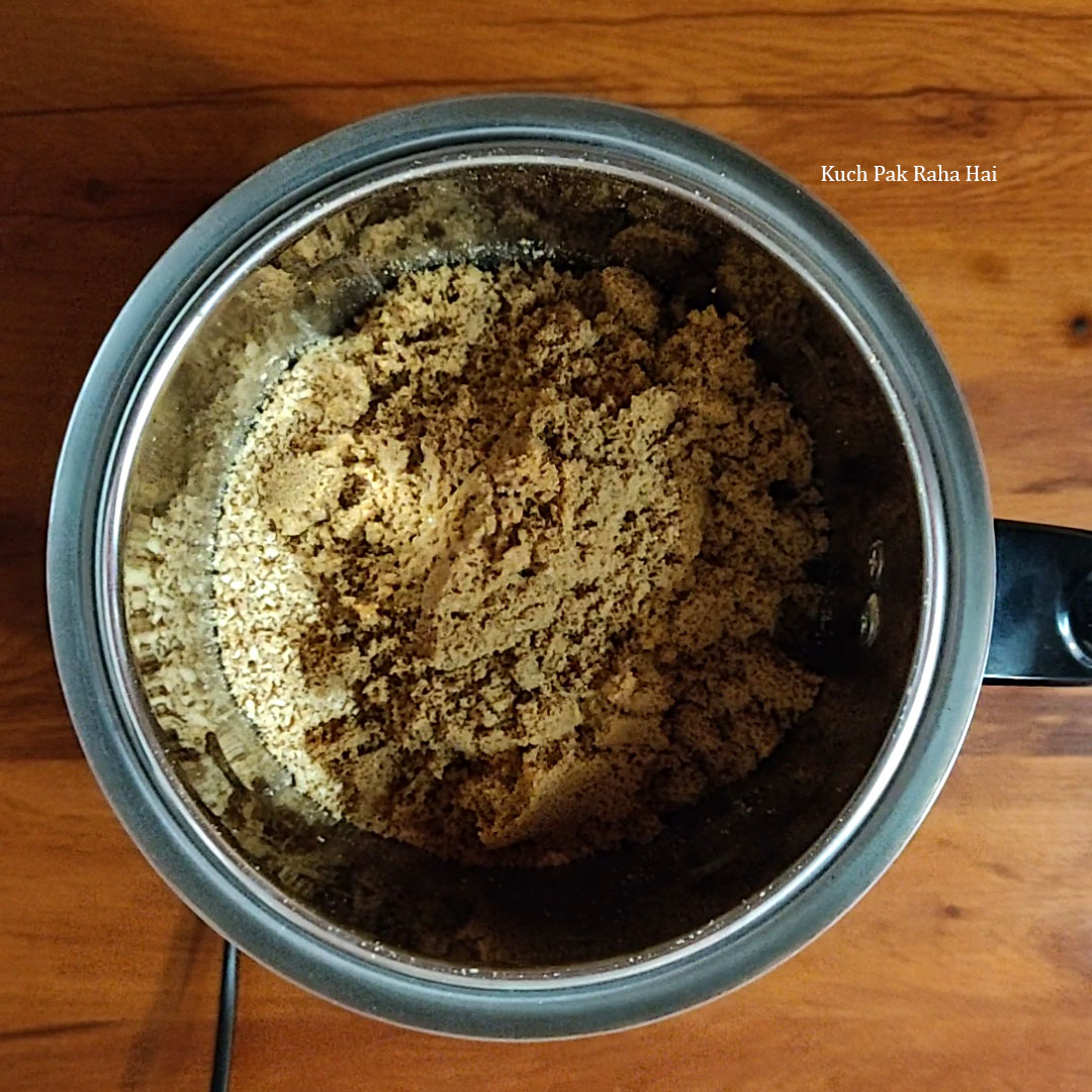 Grinding sesame, jaggery and cardamom in grinding jar.