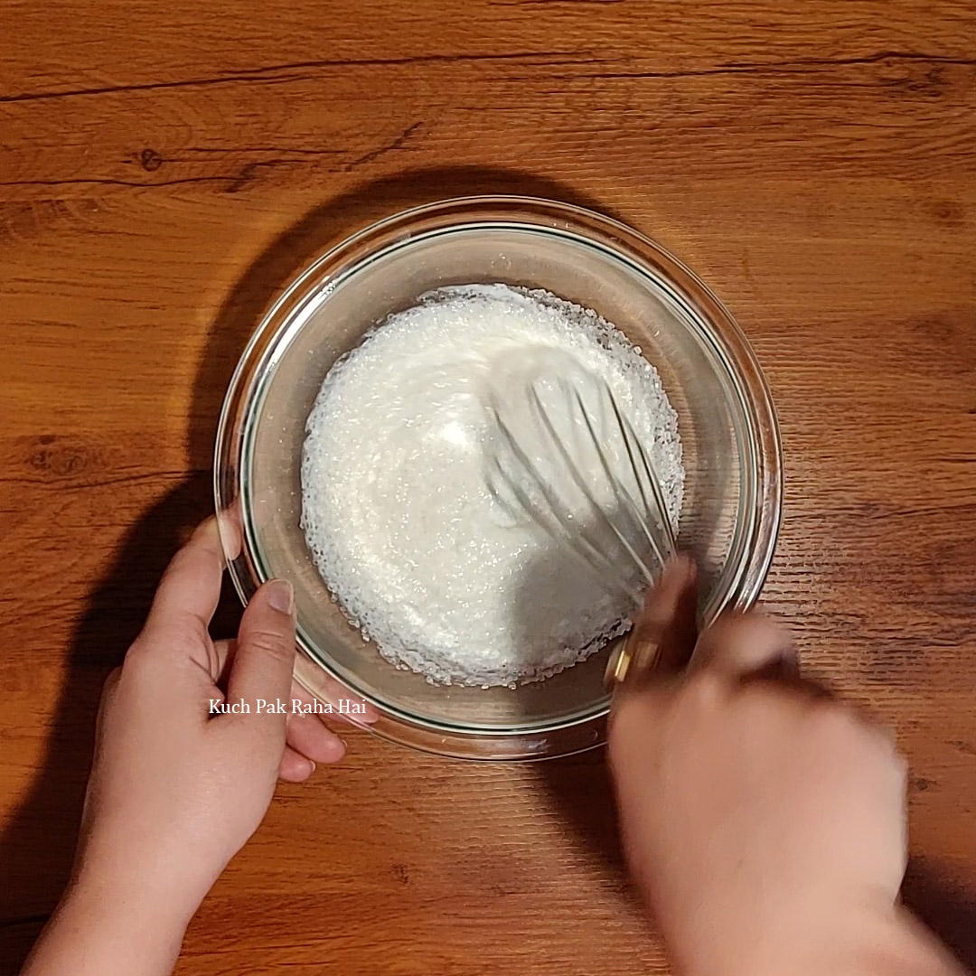 Whisking yogurt & sugar.