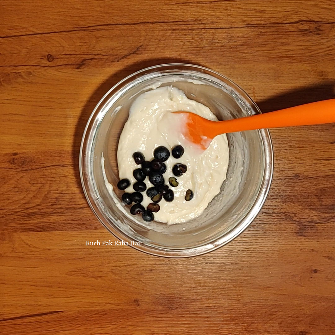 Adding fresh blueberries to the batter.